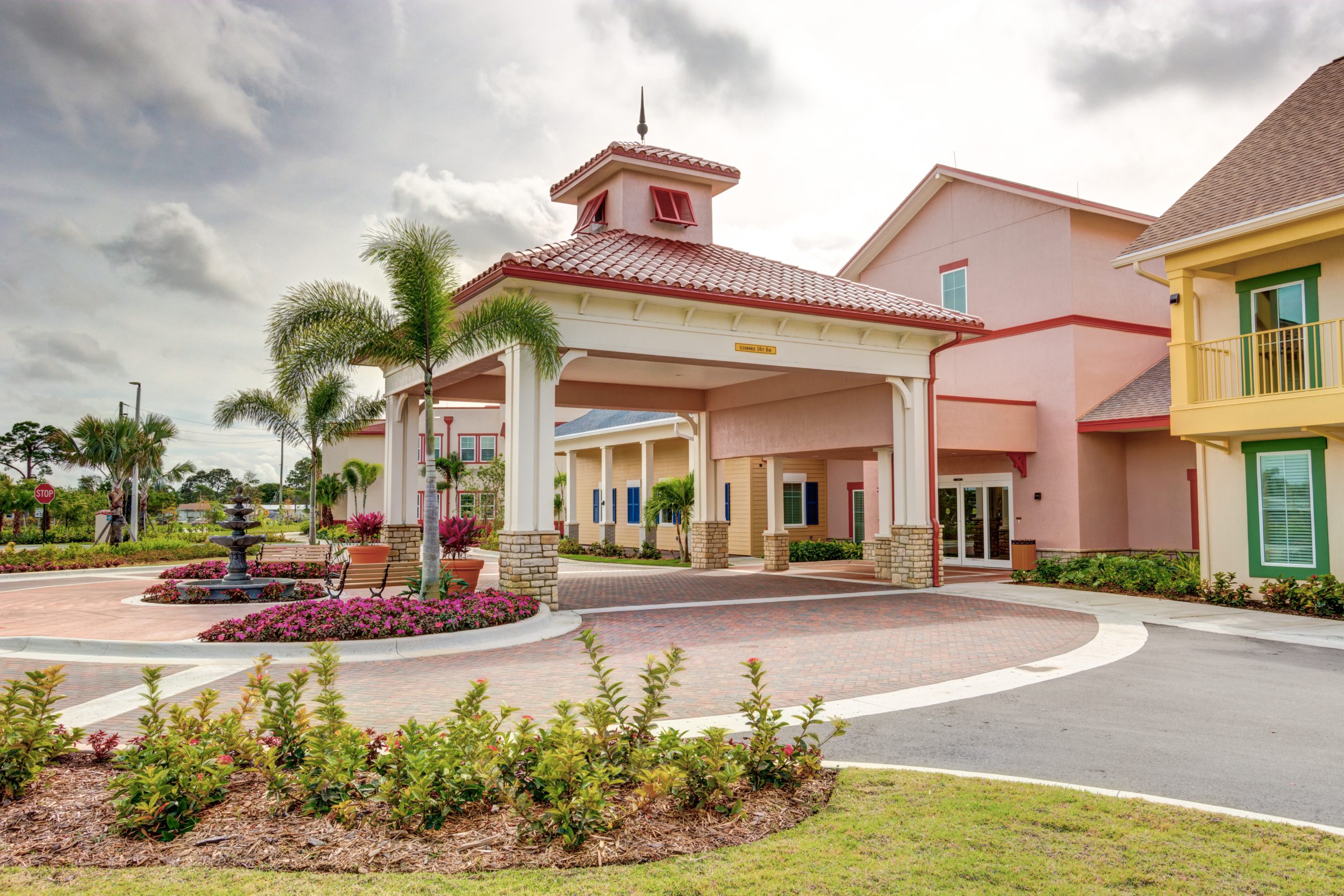 a building with a fountain and palm trees