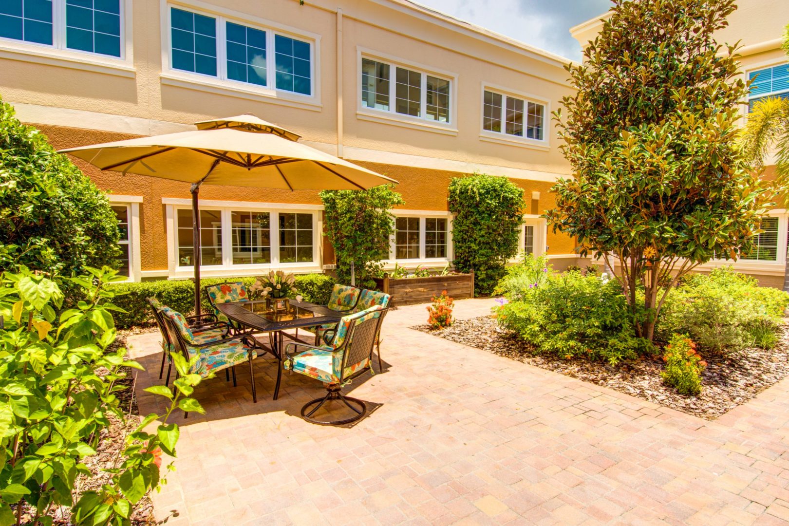 a patio with chairs and umbrella in front of a building
