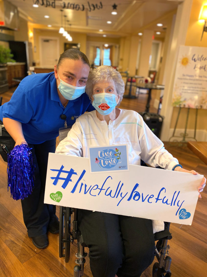 a person in a wheelchair with a sign and pom