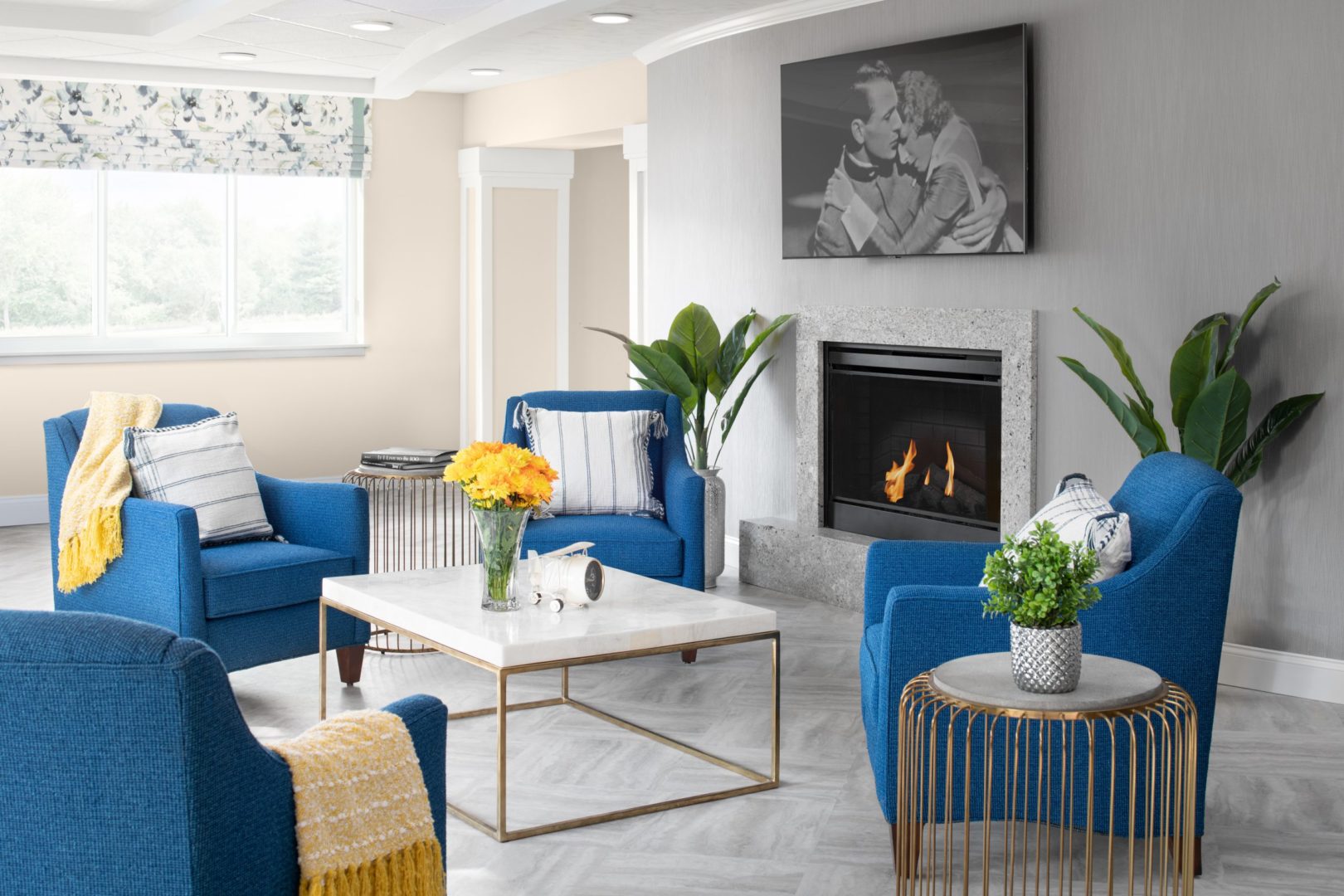 a living room with blue chairs and a fireplace