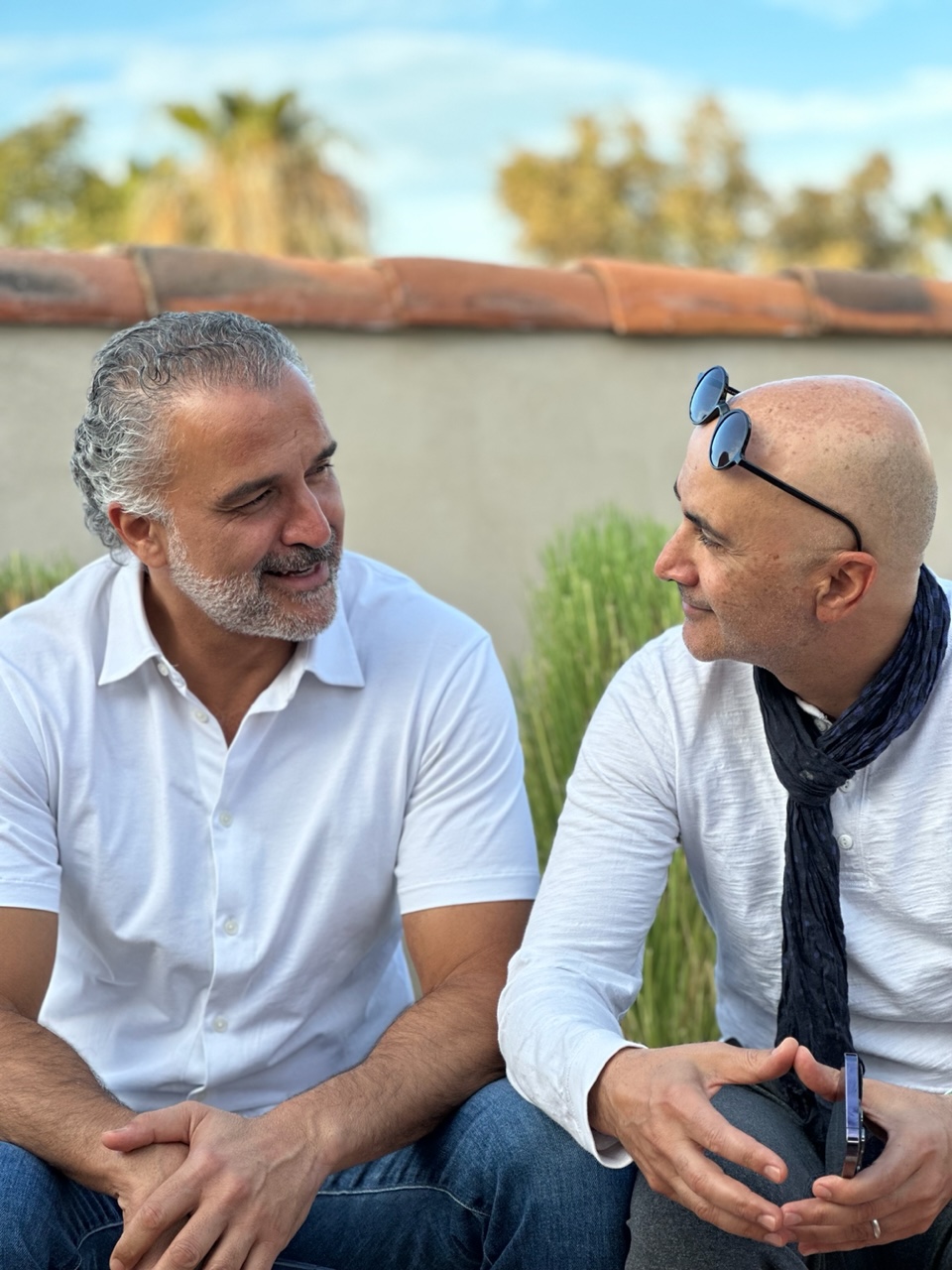 two men sitting outside talking