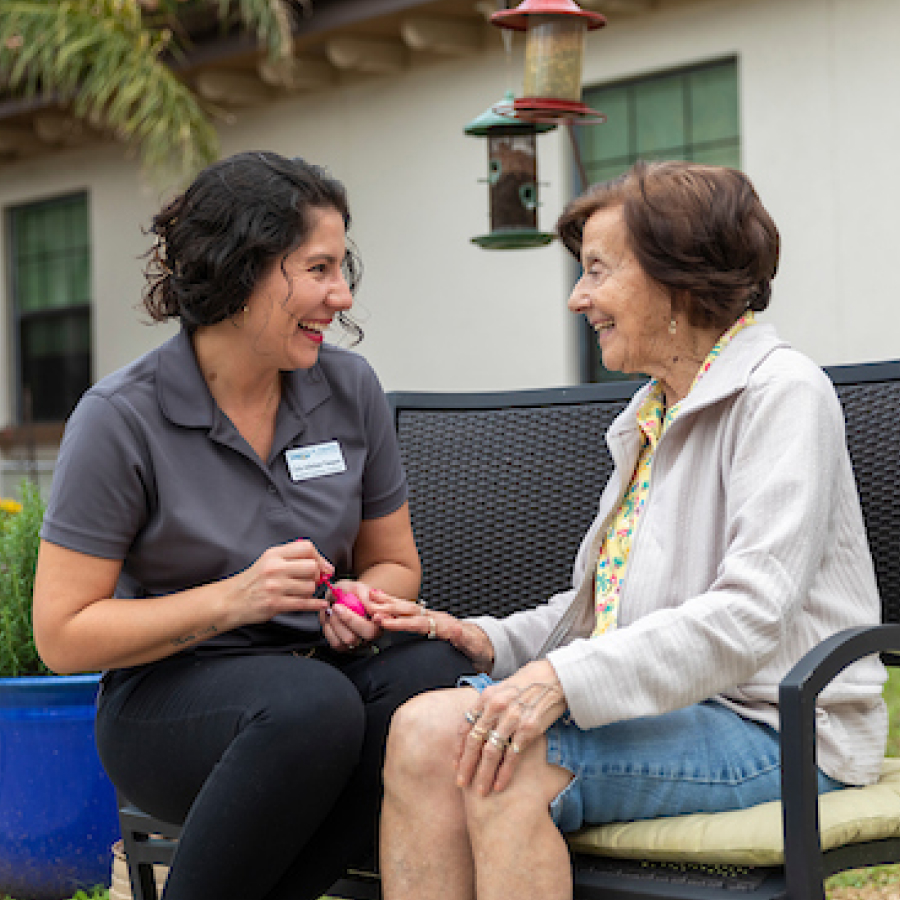 a person sitting on a bench with an older person smiling