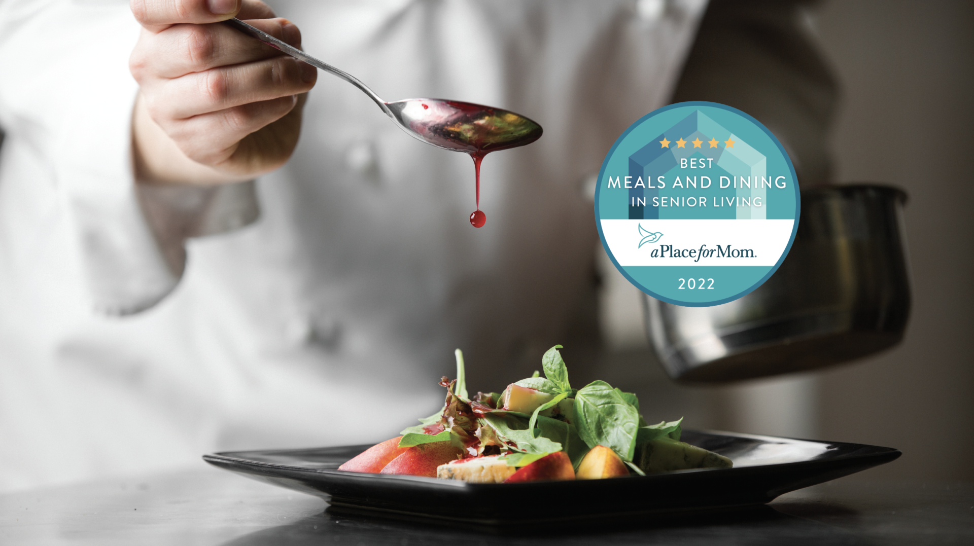 a person pouring a red liquid onto a spoon over a plate of food