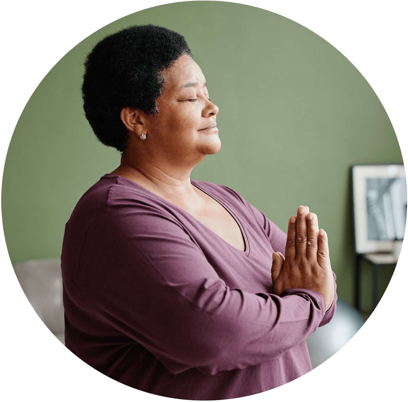 a person with her eyes closed and hands together in prayer